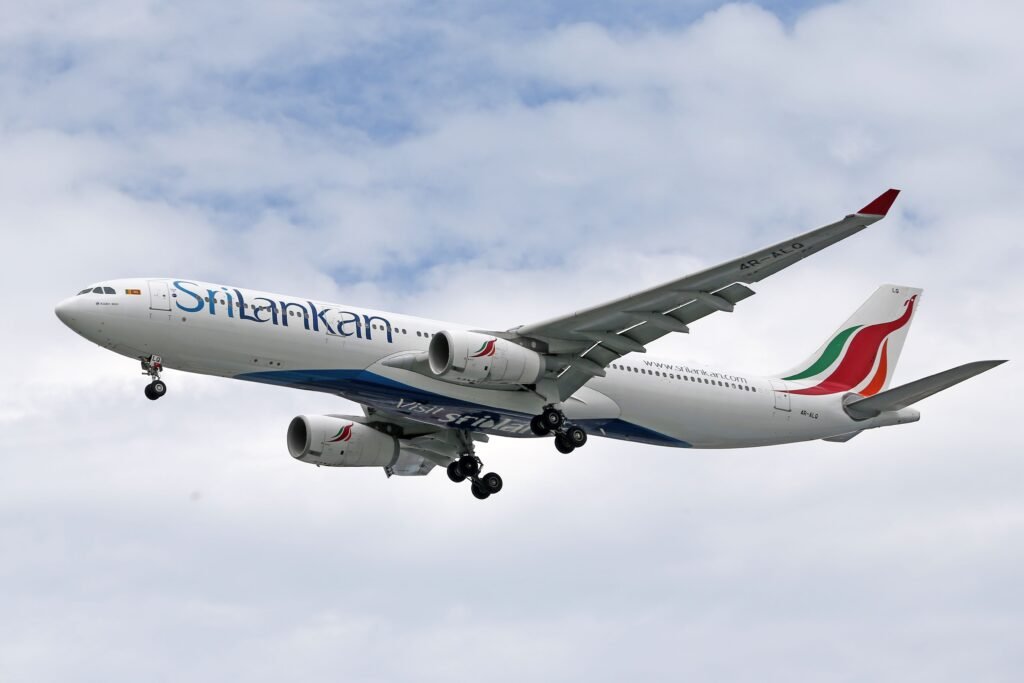 View of a SriLankan Airlines Airbus A330 in flight against a cloudy sky.