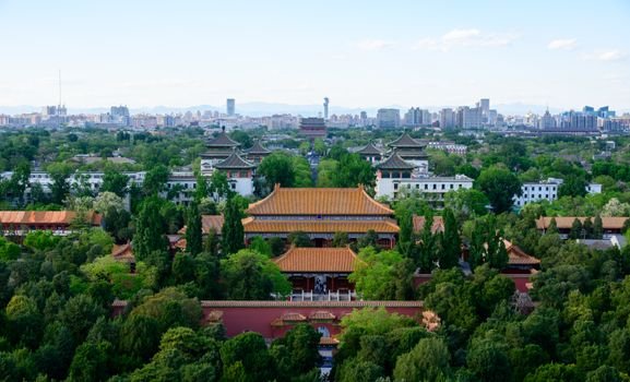 A stunning aerial view of ancient Chinese architecture with Beijing's city skyline in the background.