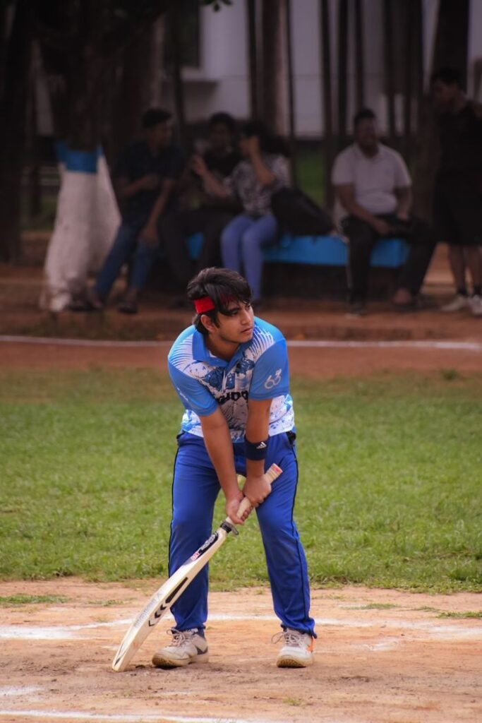 Focused young man playing cricket outdoors, ready to hit the ball.