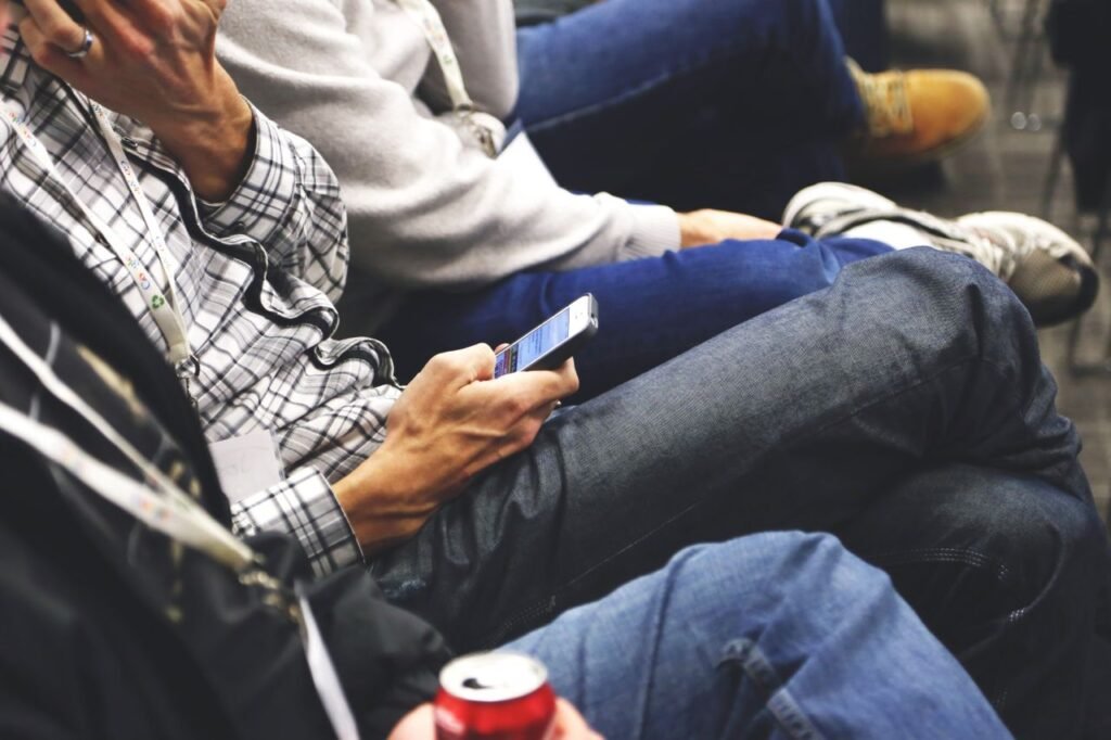 People sitting at a conference casually checking smartphones, communicating and networking.